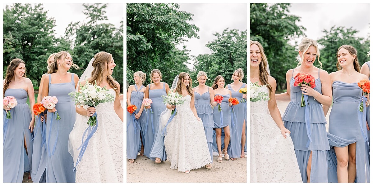 A stunning bride walks with all of her bridesmaids who are all weary dusty blue dresses while they all smile at each other in the cherry orchards on Leelanau Peninula before her emotional Bay View wedding in Traverse City.
