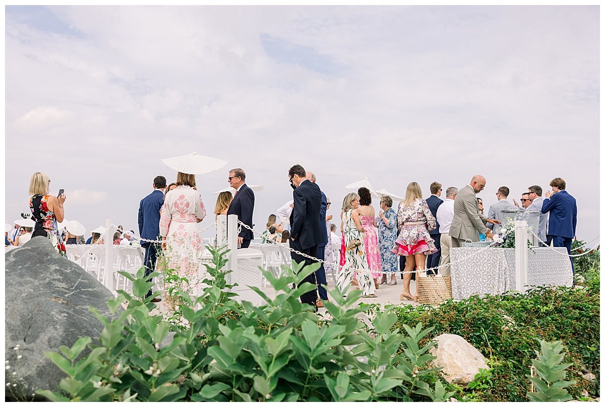 Wedding guests gather on the hilltop ceremony site at Bay View weddings at Gallagher Farms before an emotional wedding ceremony.