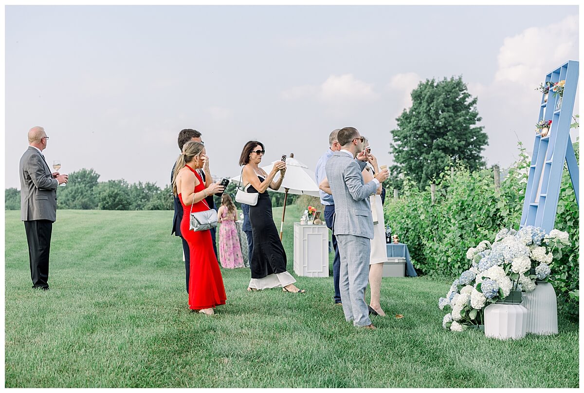 Guests mingle and look for their seating assignments on a stunning blue seating chart overlooking the bay in Northern Michigan.