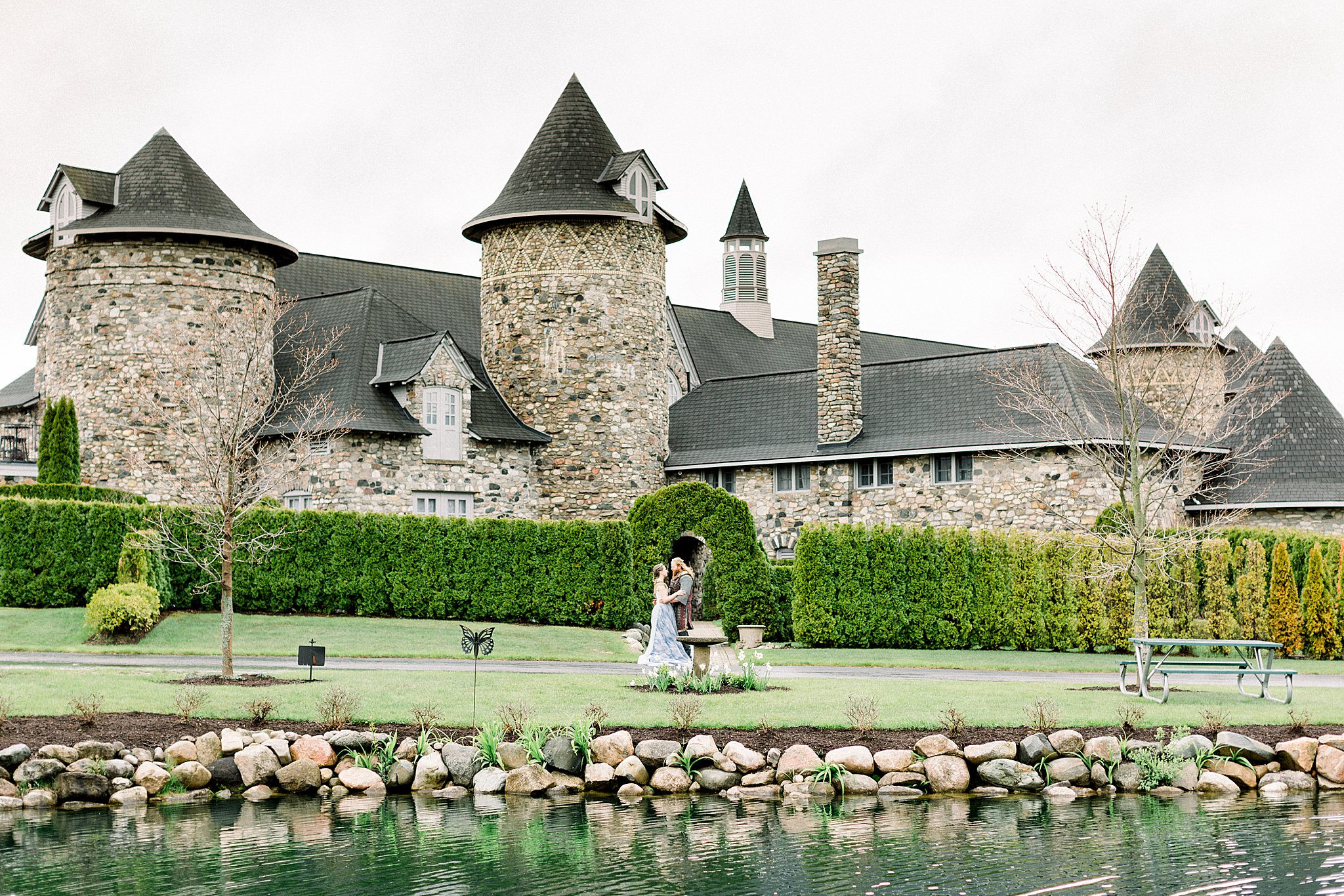 Wide shot of bride and groom standing in front of Castle for Game of Thrones wedding at Castle Farms in Charlevoix, Michigan.