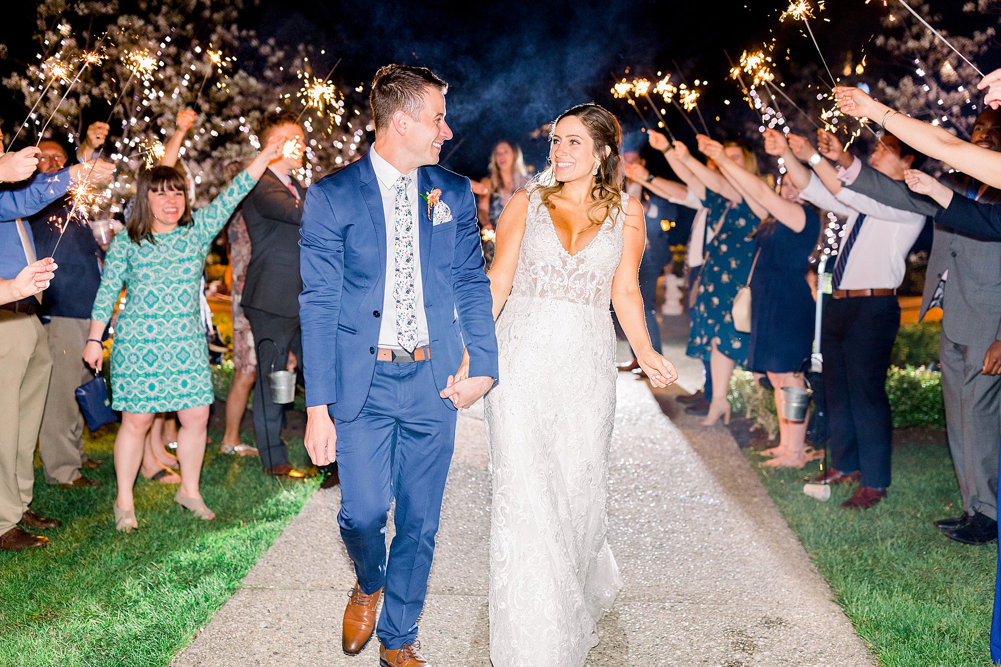 Bride and groom smile at each other during sparkler exit at spring Castle Farms wedding.