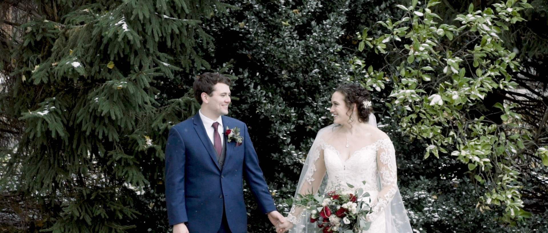 Bride and groom smile at each other during their snowy Michigan winter wedding.