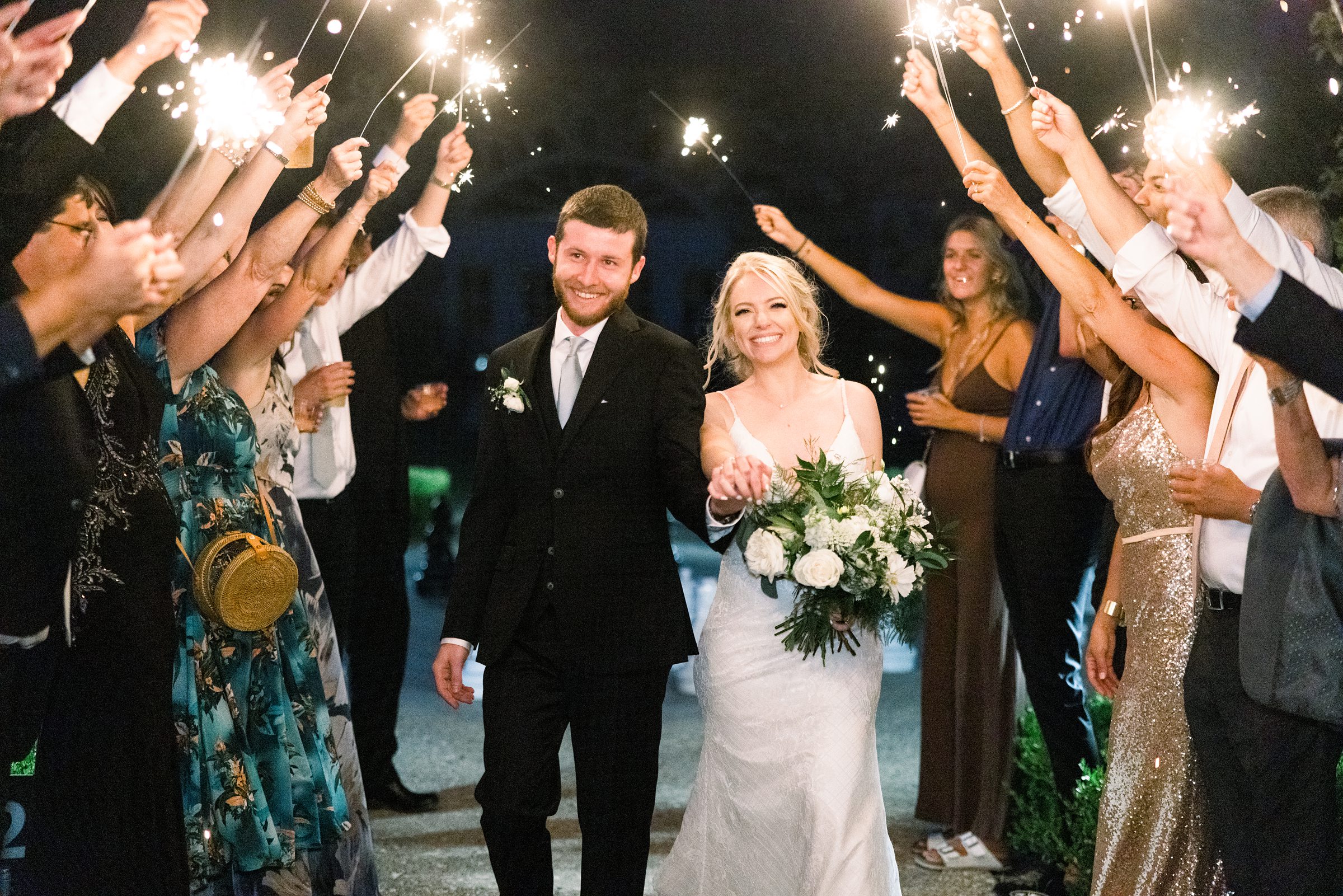 Bride and groom walk through sparkler exit at Castle Farms