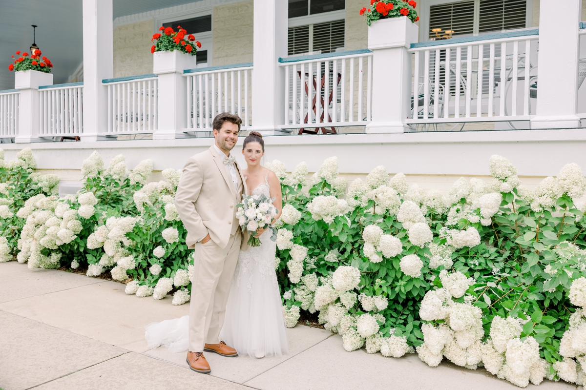 Alyssa and Marcus smiling in front of the Perry Hotel on their wedding day.