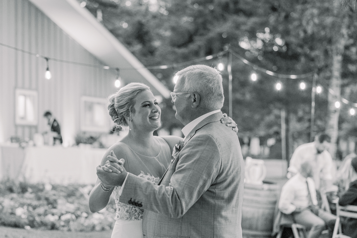 Black and white photo of Caitlin and her dad during their father daughter dance on her wedding day.