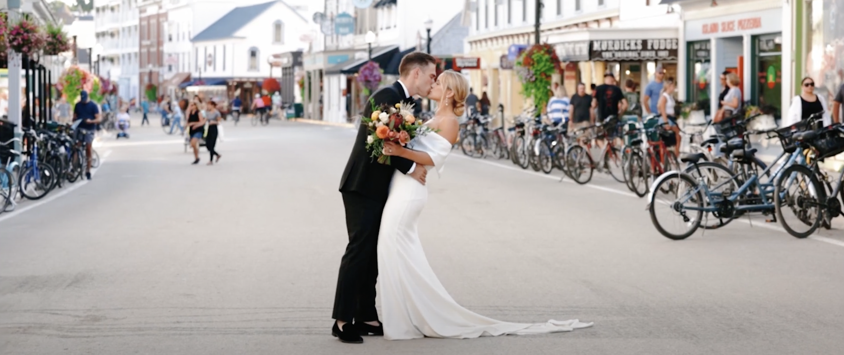 Bride and groom kissing on main street of Mackinac Island.